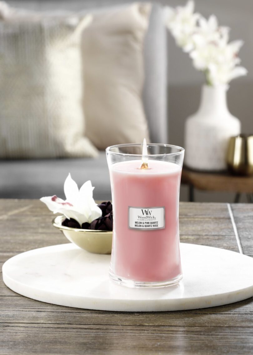 Een foto van een verfrissende WoodWick kaars met de geur van Melon & Pink Quartz, beschikbaar bij ThuisbijSerena, die een licht en fruitig aroma in huis verspreidt.